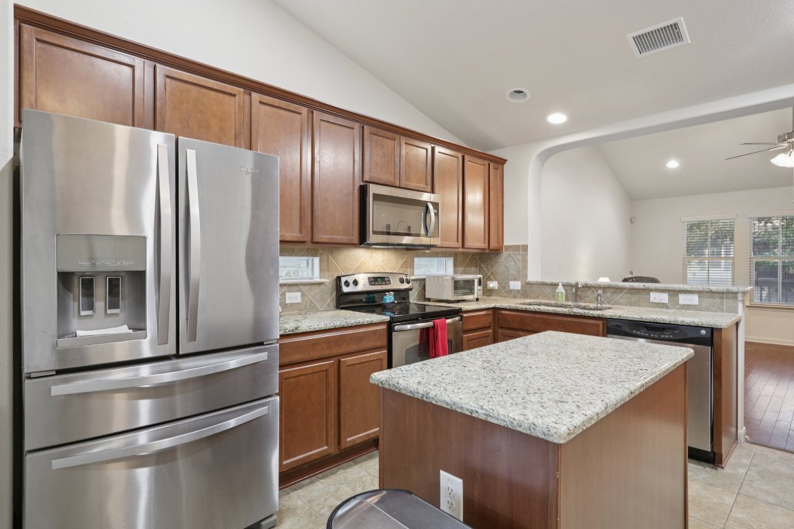 1621 Big Thicket Drive Cedar Park, TX 78613 - Photo 16 of 37 a kitchen with a refrigerator a microwave a sink and a stove
