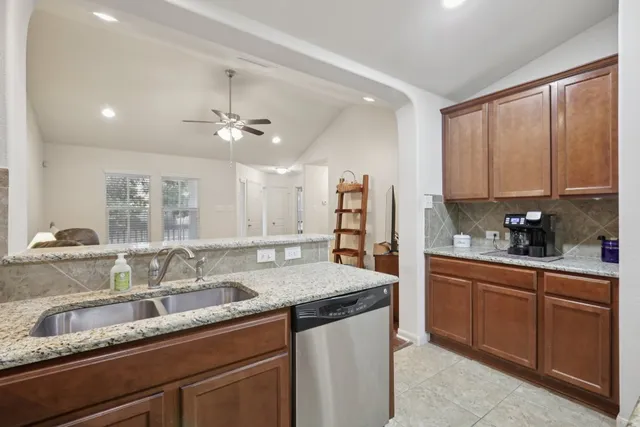 a kitchen with stainless steel appliances granite countertop a sink a stove and cabinets