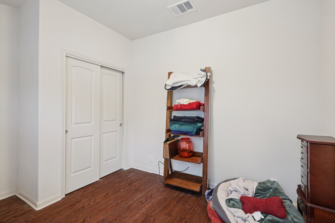 1621 Big Thicket Drive Cedar Park, TX 78613 - Photo 19 of 37 a bedroom with a bed and wooden floor