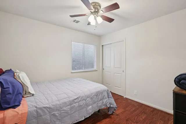 a bedroom with a bed and a ceiling fan