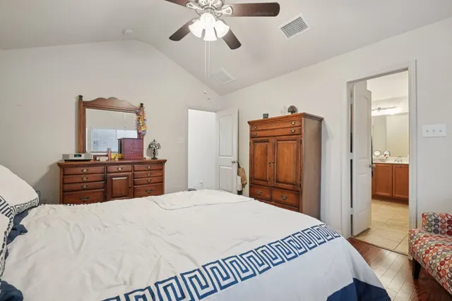 a bedroom with a bed and dresser with mirror