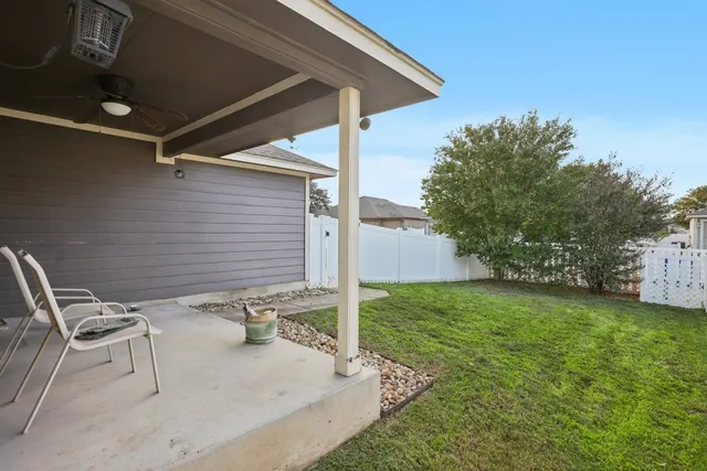 a backyard of a house with table and chairs