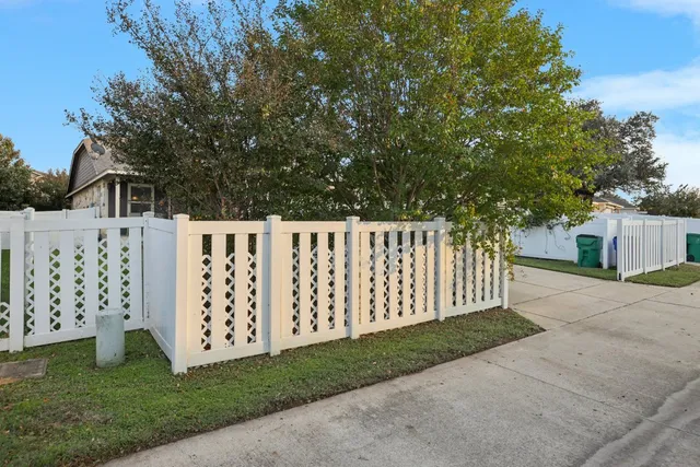 a white house covered with trees in front of it
