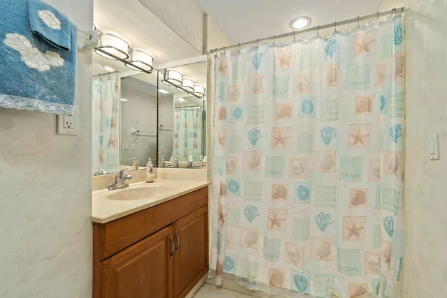 a bathroom with a sink mirror and shower