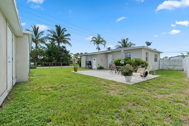 a view of a house with a yard and potted plants