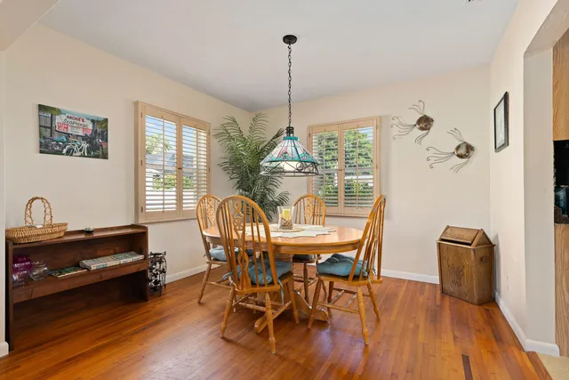 a dining room with furniture a chandelier and wooden floor