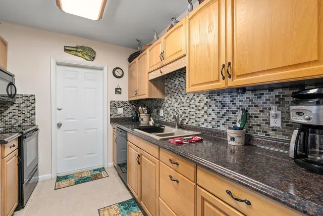 a kitchen with stainless steel appliances granite countertop a sink a stove and a microwave