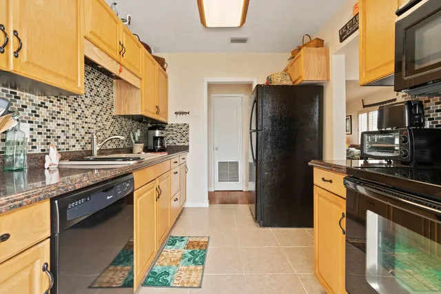 a kitchen with stainless steel appliances granite countertop a refrigerator a stove and a sink