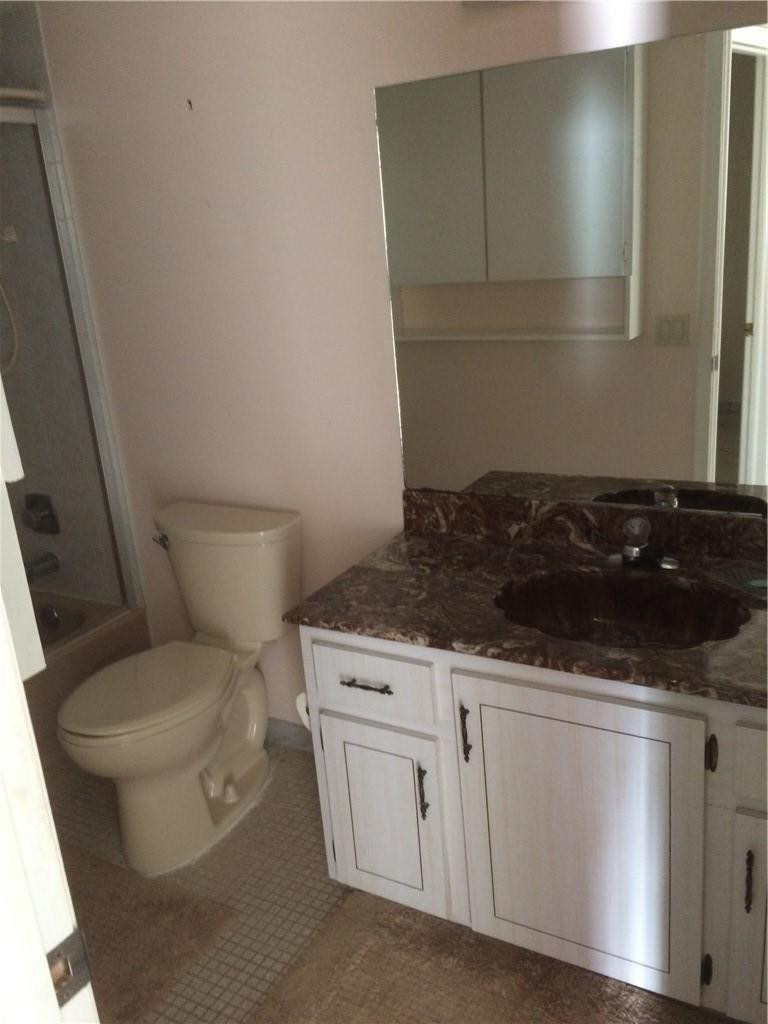 3571 Inverrary Drive, Unit 308 Lauderhill, FL 33319 - Photo 2 of 9 a bathroom with a granite countertop toilet and a sink