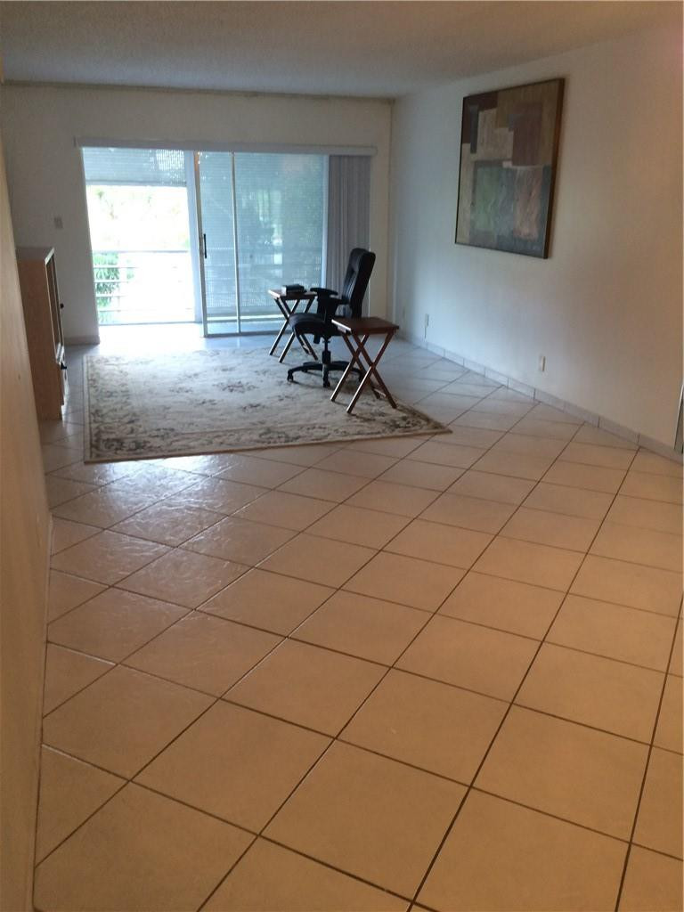 3571 Inverrary Drive, Unit 308 Lauderhill, FL 33319 - Photo 8 of 9 a living room with a couch and a table in it