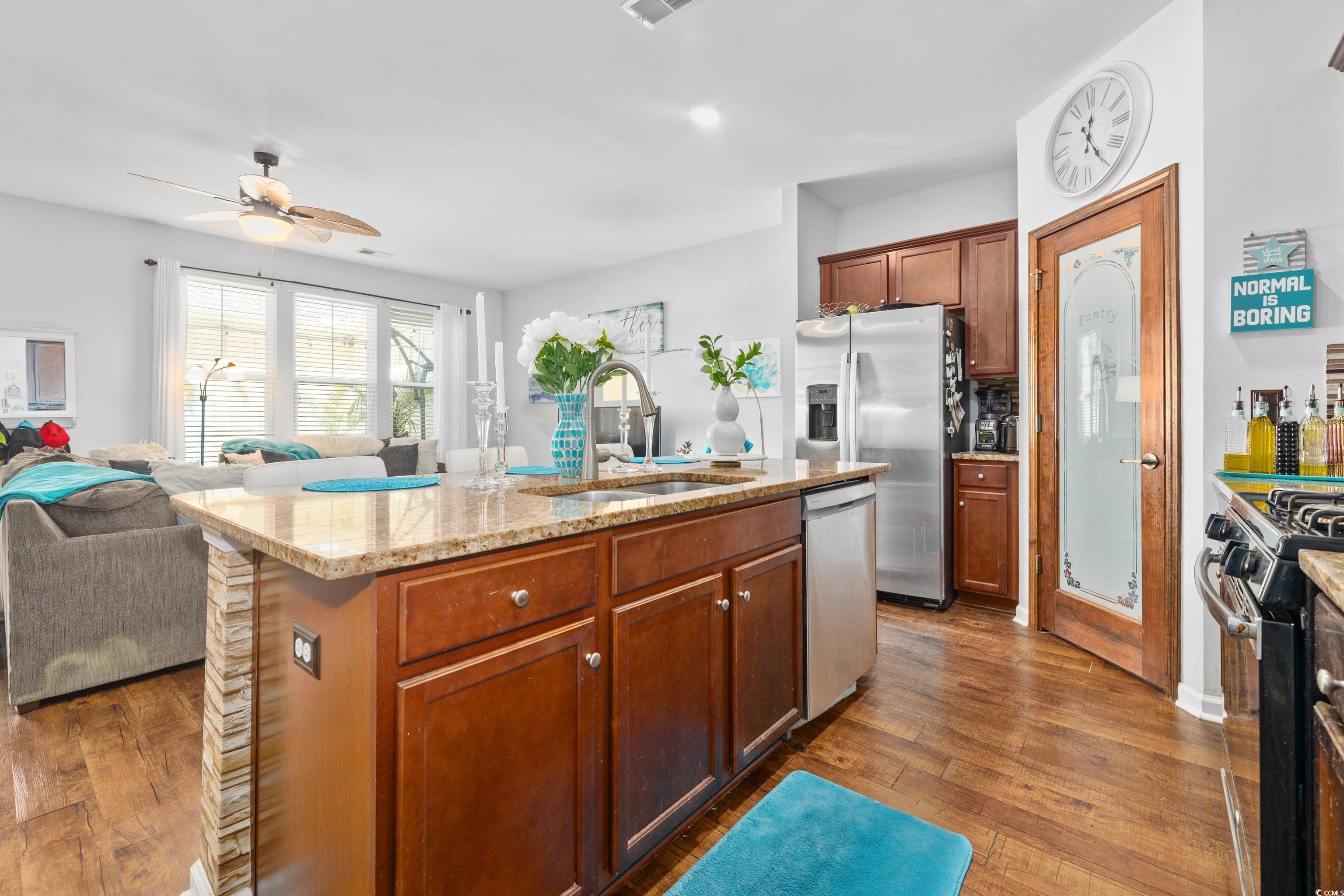 2360 Heritage Loop, Unit 2360 Myrtle Beach, SC 29577 - Photo 38 of 38 Kitchen featuring open floor plan, appliances with stainless steel finishes, light stone countertops, brown cabinetry, and dark wood-style flooring