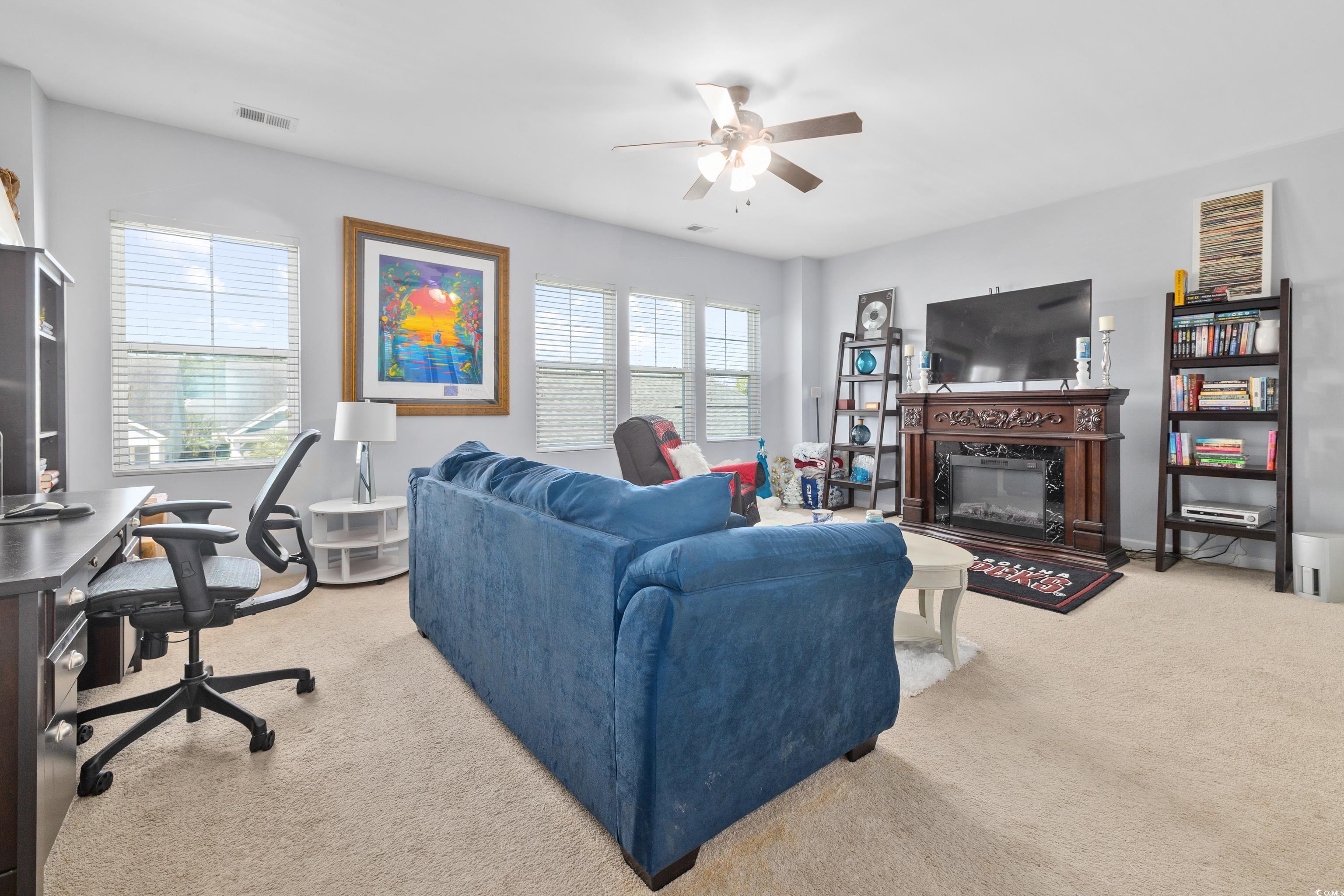 2360 Heritage Loop, Unit 2360 Myrtle Beach, SC 29577 - Photo 26 of 38 Living room featuring light colored carpet, an office area, a fireplace, and ceiling fan