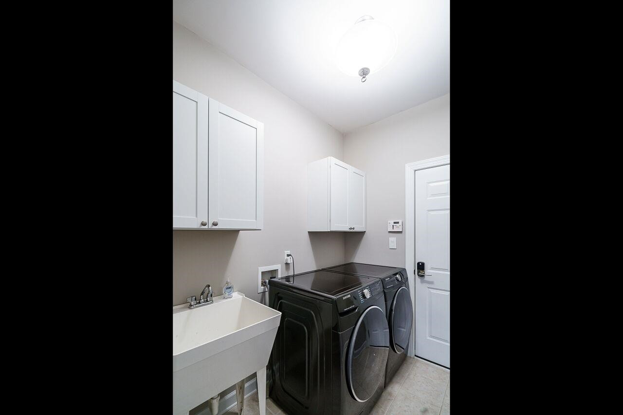 3003 Red Grape Drive Raleigh, NC 27607 - Photo 22 of 35 Easy maintenance utility room with included washer/dryer, laundry sink and newly installed cabinetry. Laundry Room