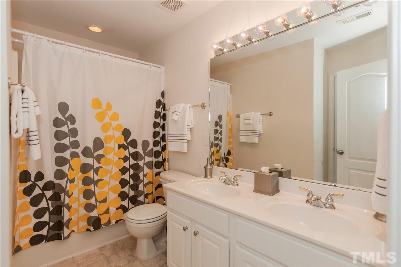 7613 Silver View Lane Raleigh, NC 27613 - Photo 19 of 25 The upstairs hall bathroom has plenty of space for everyone with its double vanity and under-counter cabinet space.