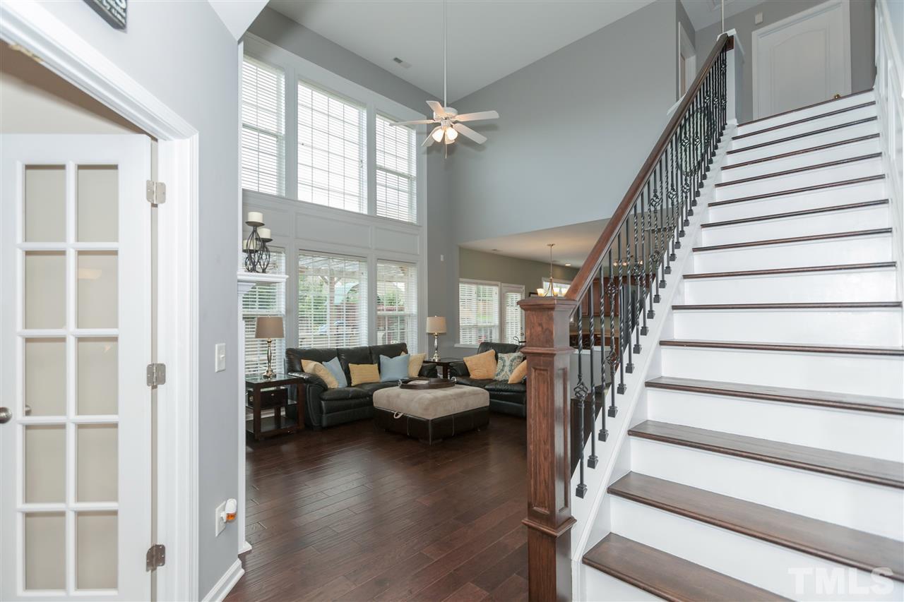 7613 Silver View Lane Raleigh, NC 27613 - Photo 4 of 25 Another view of the family room's wall of windows and hardwood stairs with wrought iron spindles.