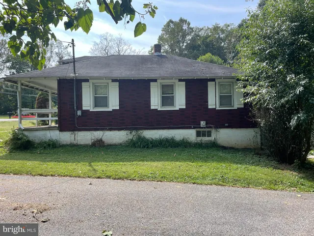 a view of a house with a yard and sitting area