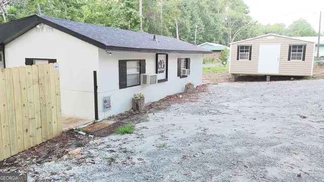 a view of a house with a yard and large tree