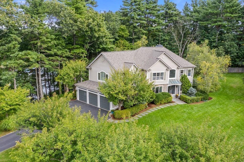 a aerial view of a house with swimming pool next to a big yard