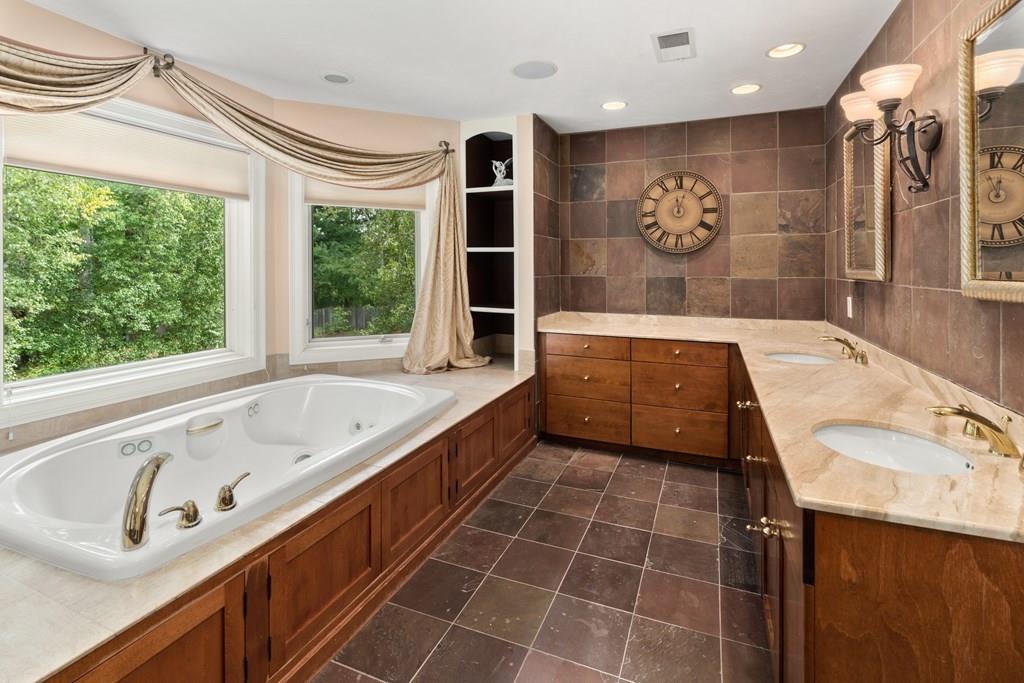 7 Pettees Pond Lane Walpole, MA 02081 - Photo 19 of 38 a bathroom with a tub a sink and a large mirror