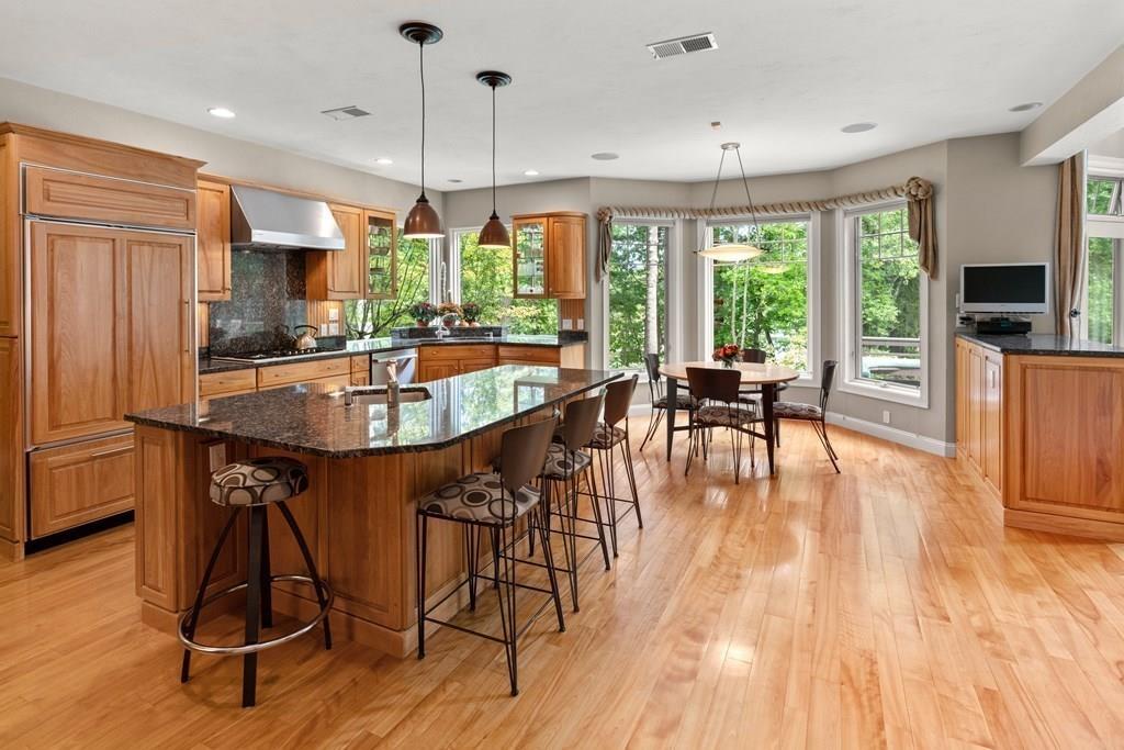7 Pettees Pond Lane Walpole, MA 02081 - Photo 4 of 38 a dining room with wooden floor a chandelier a glass table and chairs