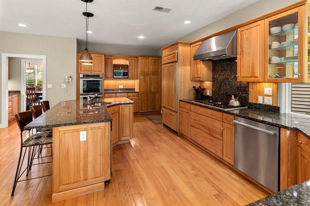7 Pettees Pond Lane Walpole, MA 02081 - Photo 6 of 38 a kitchen with stainless steel appliances granite countertop sink stove top oven and cabinets