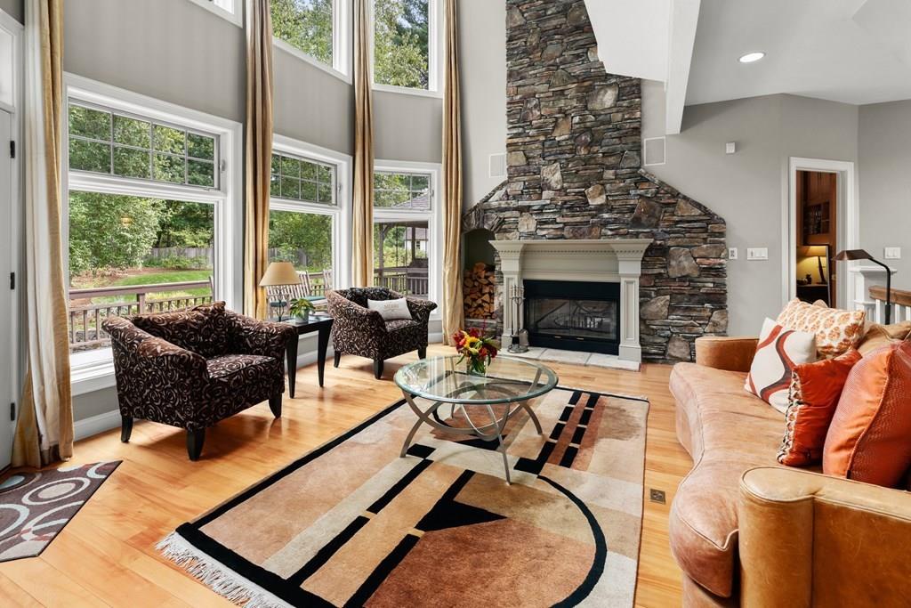 7 Pettees Pond Lane Walpole, MA 02081 - Photo 10 of 38 a living room with furniture a fireplace and a floor to ceiling window