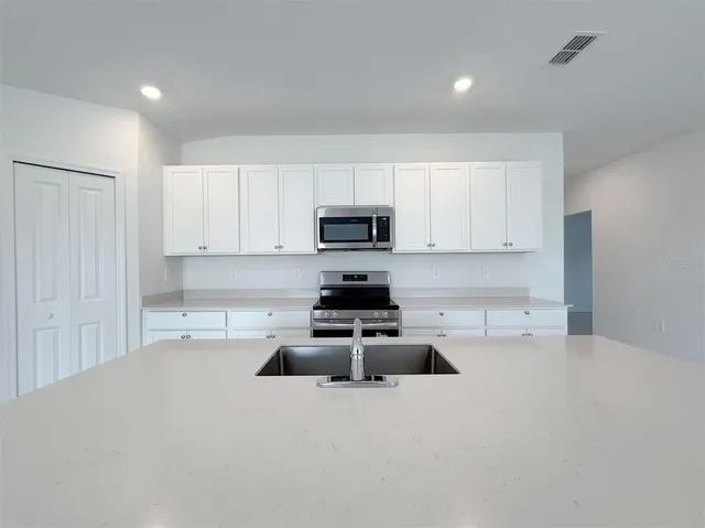 a kitchen with granite countertop a stove and a sink