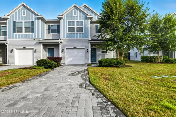 a front view of a house with a yard and trees
