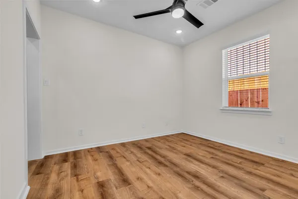 a view of empty room with wooden floor
