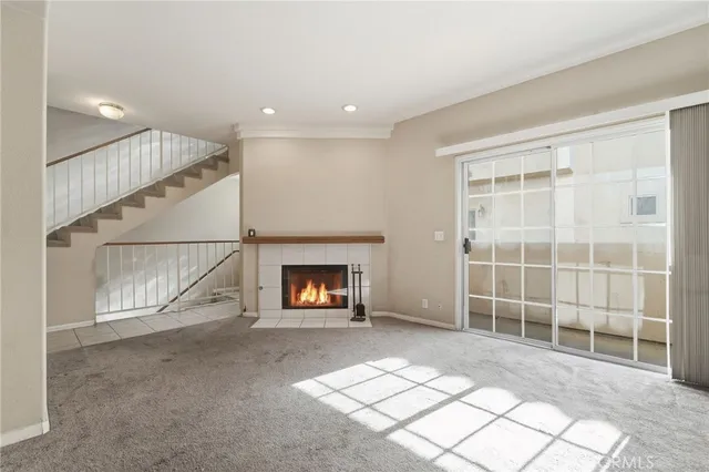 a view of an empty room with a fireplace and a window