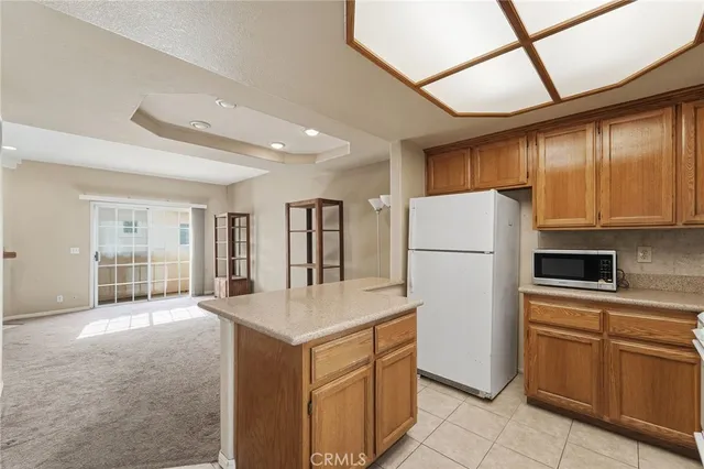 a kitchen with a refrigerator a stove top oven and a large window