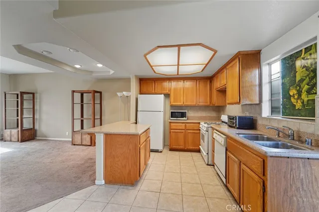 a kitchen with a sink a counter top space and stainless steel appliances