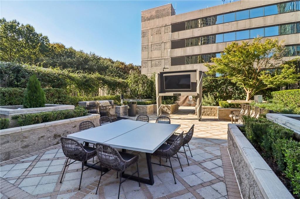 3445 Stratford Road Northeast, Unit 2602 Atlanta, GA 30326 - Photo 11 of 56 a view of a patio with a table and chairs next to a yard