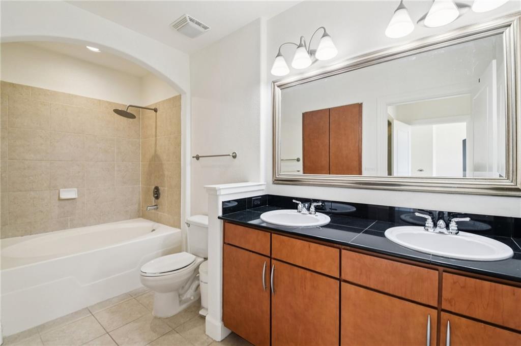3445 Stratford Road Northeast, Unit 2602 Atlanta, GA 30326 - Photo 30 of 56 a bathroom with a granite countertop sink a toilet a mirror and bathtub