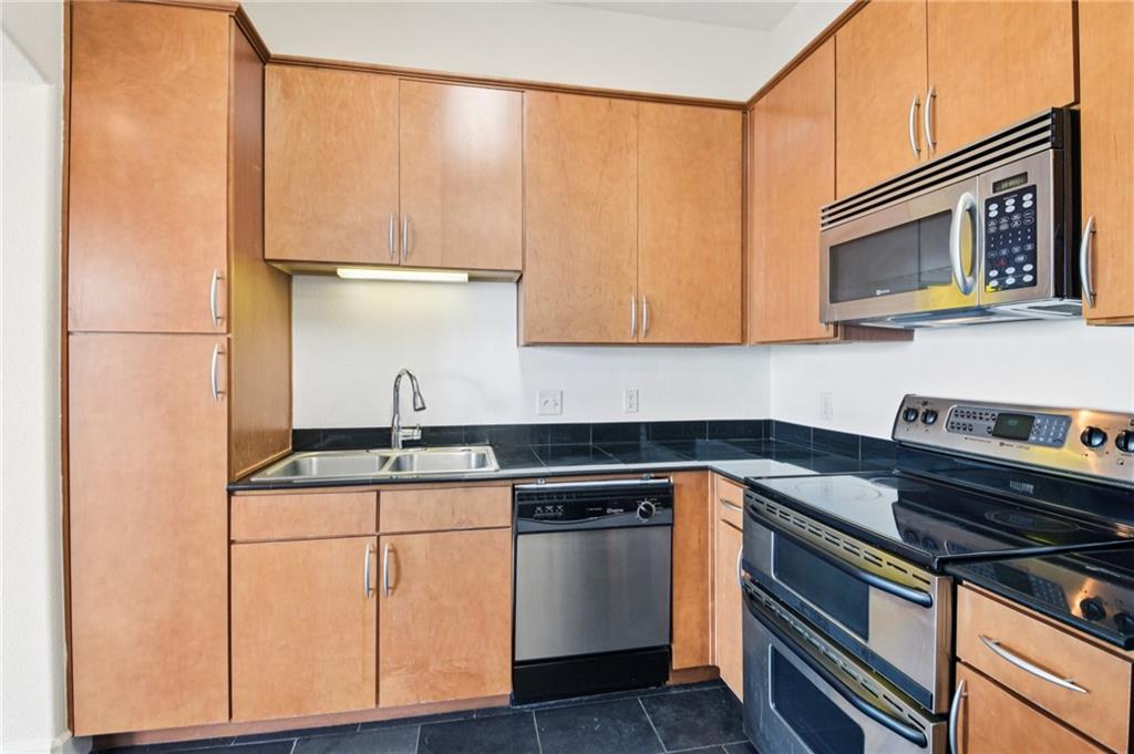 3445 Stratford Road Northeast, Unit 2602 Atlanta, GA 30326 - Photo 40 of 56 a kitchen with stainless steel appliances granite countertop a sink stove and microwave