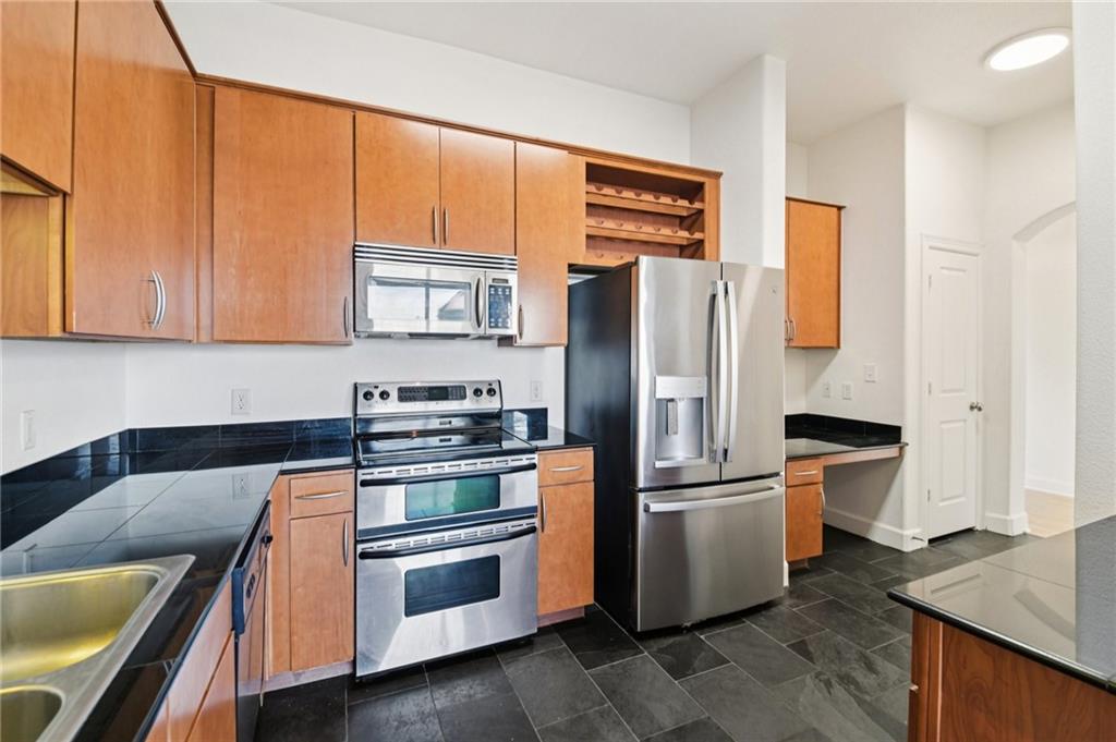 3445 Stratford Road Northeast, Unit 2602 Atlanta, GA 30326 - Photo 42 of 56 a kitchen with stainless steel appliances granite countertop a refrigerator a stove and a sink with wooden floor