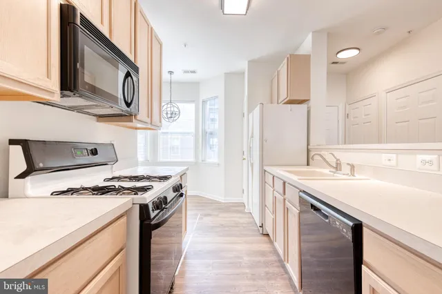 a kitchen with stainless steel appliances granite countertop a sink and a stove