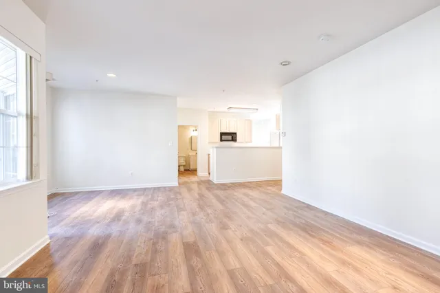 a view of a kitchen with wooden floor and windows