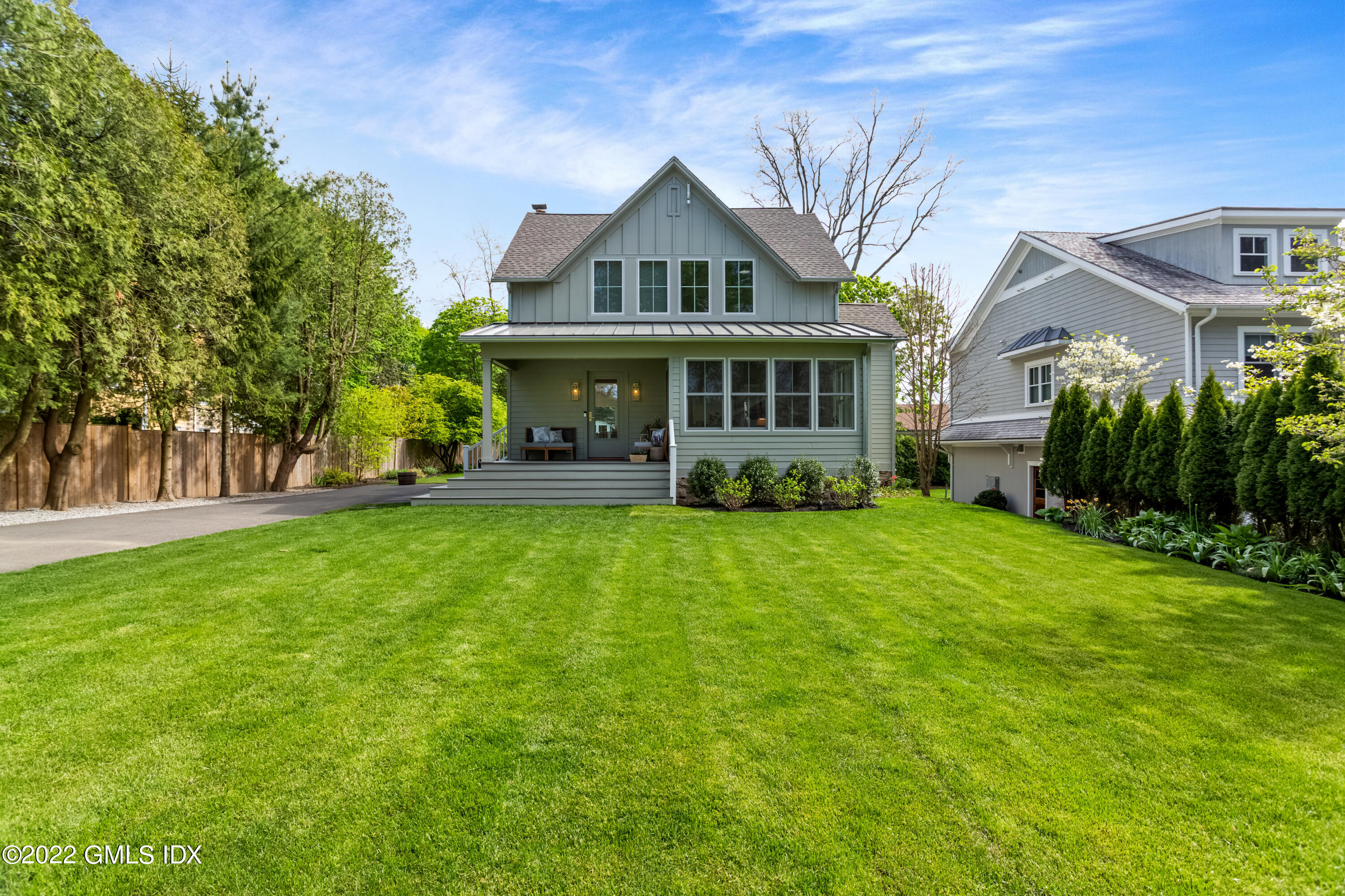 6 Chapel Lane Riverside, CT 06878 - Photo 2 of 29 a front view of a house with a garden and trees