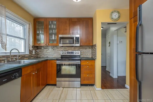 a kitchen with stainless steel appliances granite countertop a refrigerator and a sink