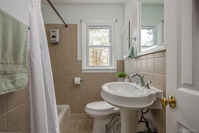 a bathroom with a sink toilet and a mirror