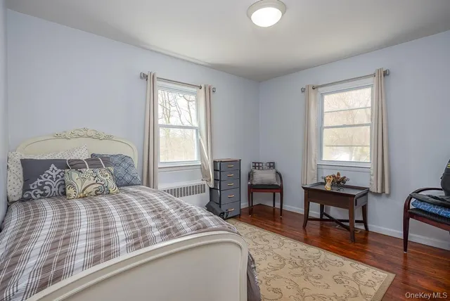 a bedroom with a bed table chair and a window