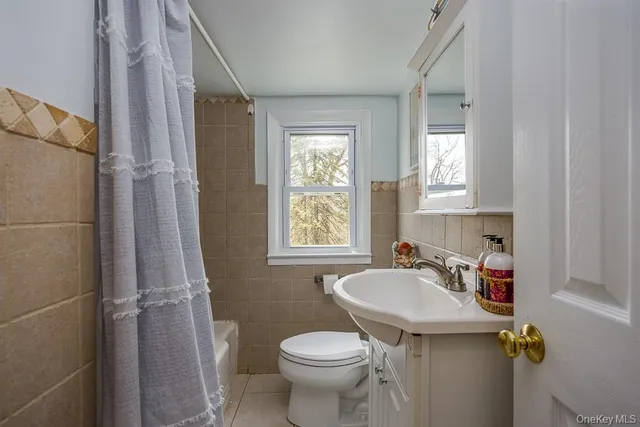 a bathroom with a sink toilet and a window