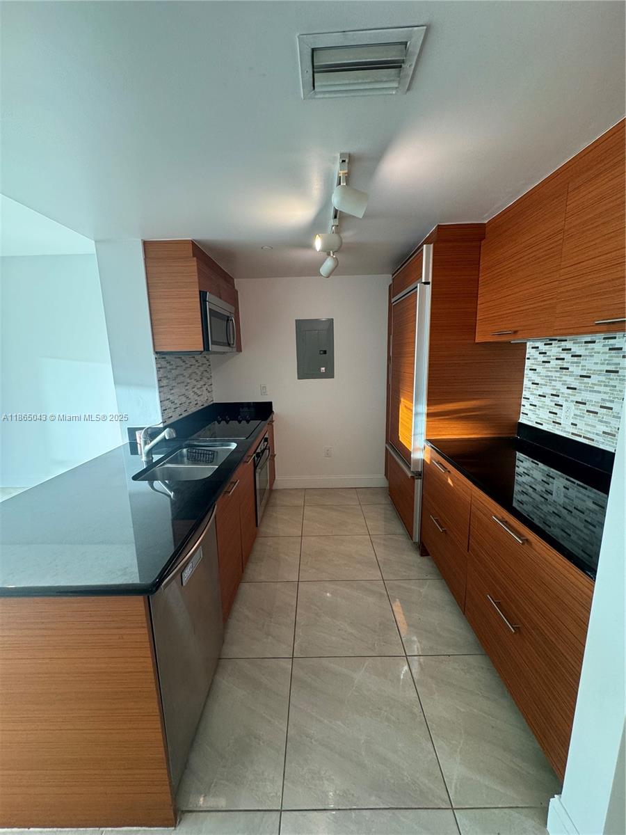 50 Biscayne Boulevard, Unit 3405 Miami, FL 33132 - Photo 11 of 40 a kitchen with stainless steel appliances granite countertop a sink and a stove