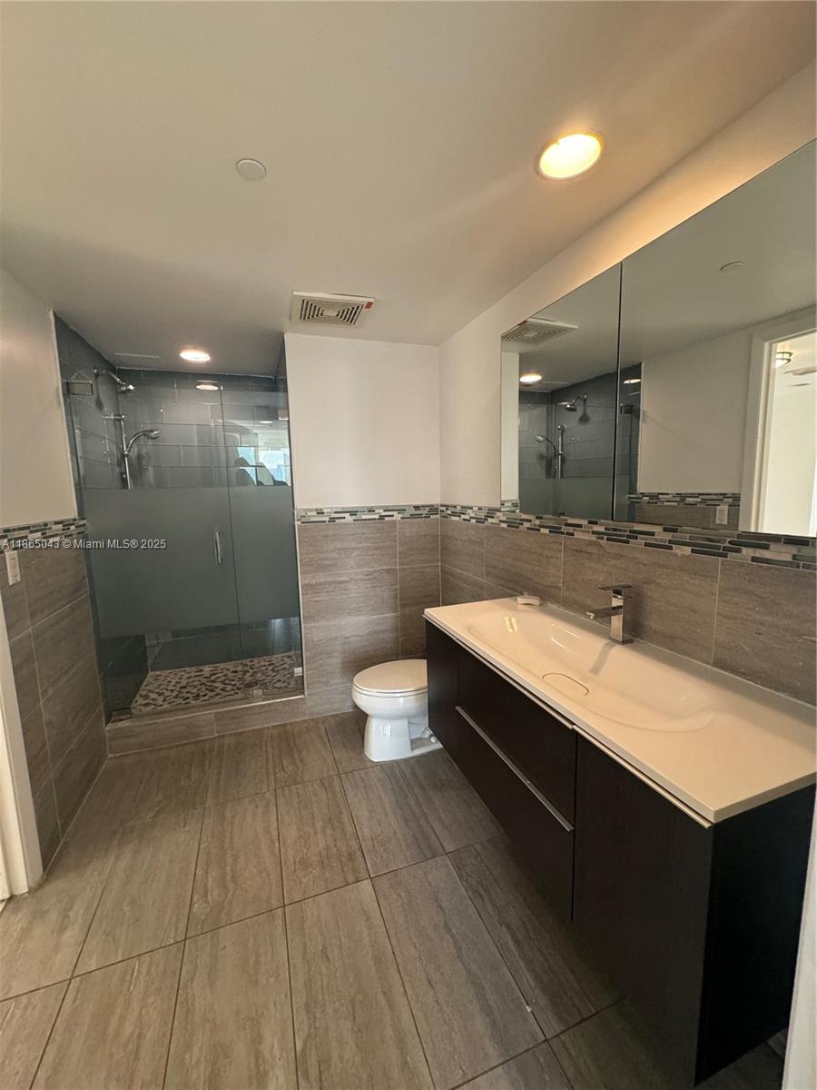 50 Biscayne Boulevard, Unit 3405 Miami, FL 33132 - Photo 13 of 40 a bathroom with a sink a toilet and a shower