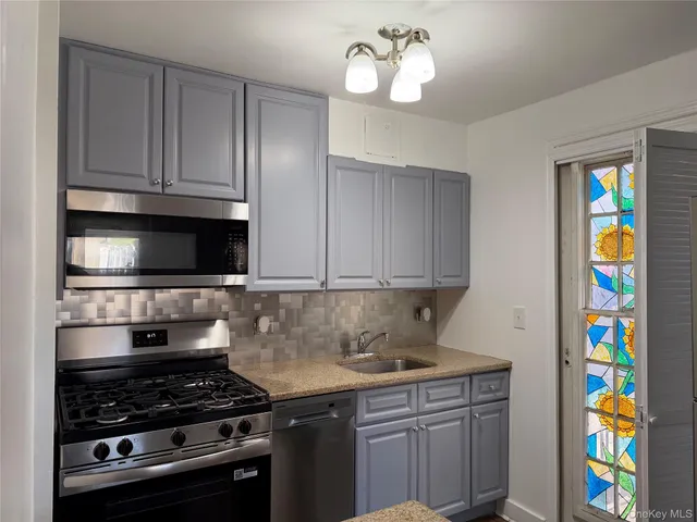 a kitchen with stainless steel appliances granite countertop a stove and cabinets