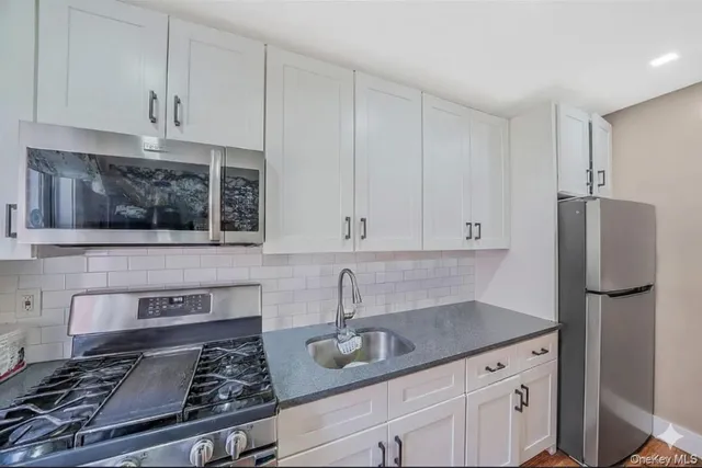 a kitchen with stainless steel appliances granite countertop a sink stove and refrigerator