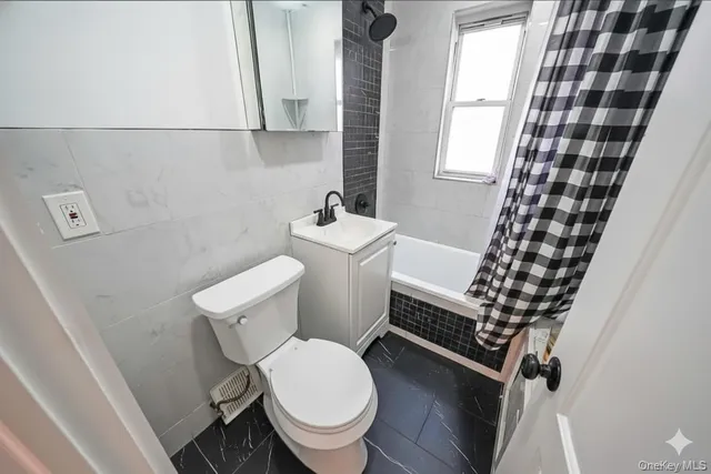 a white toilet sitting next to a bathroom sink and a window