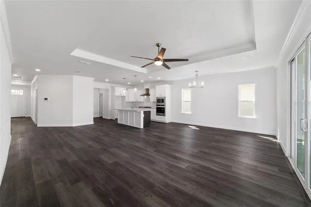 a view of empty room with wooden floor and ceiling fan