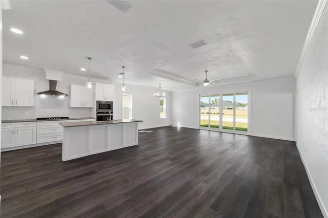 a large kitchen with stainless steel appliances refrigerator large stove and wooden floor